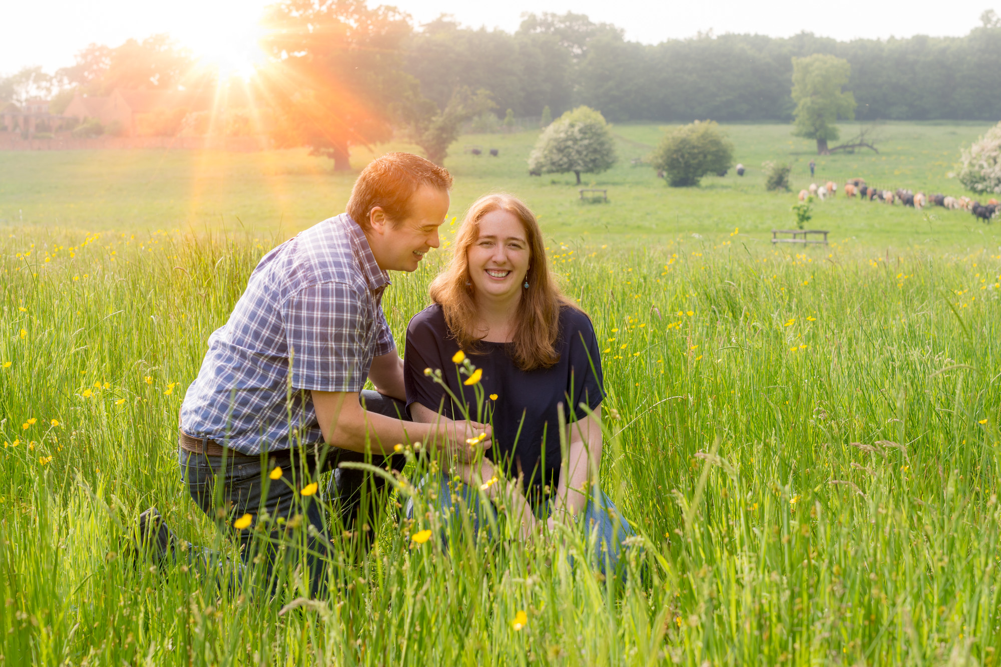 Couple photograph in field with sun